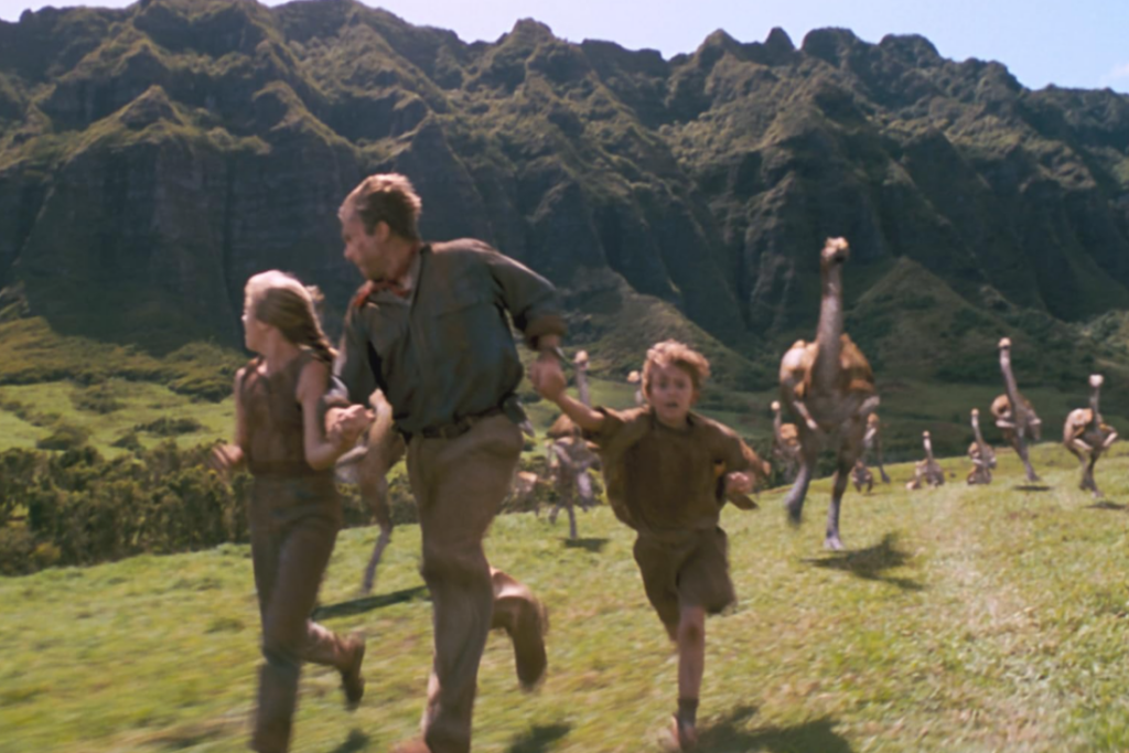 Dr. Alan Grant protects Lex and Tim as they flee dinosaurs in Jurassic Park.