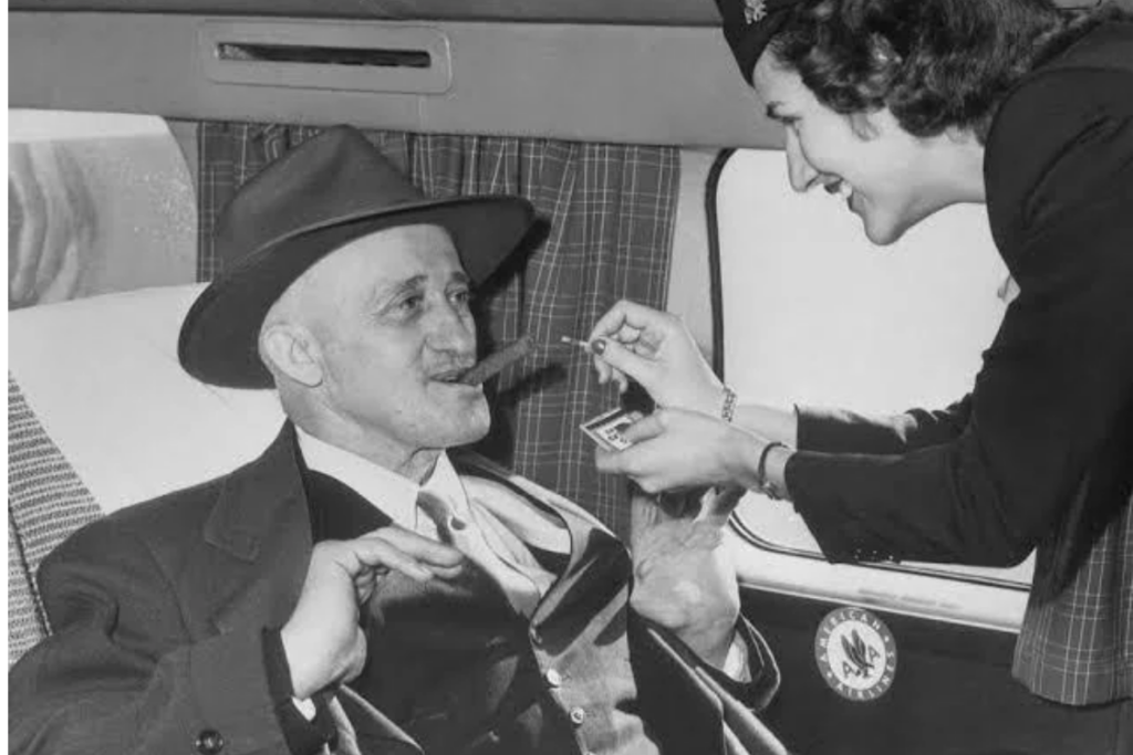 Black and white photo of a man smoking on airplane