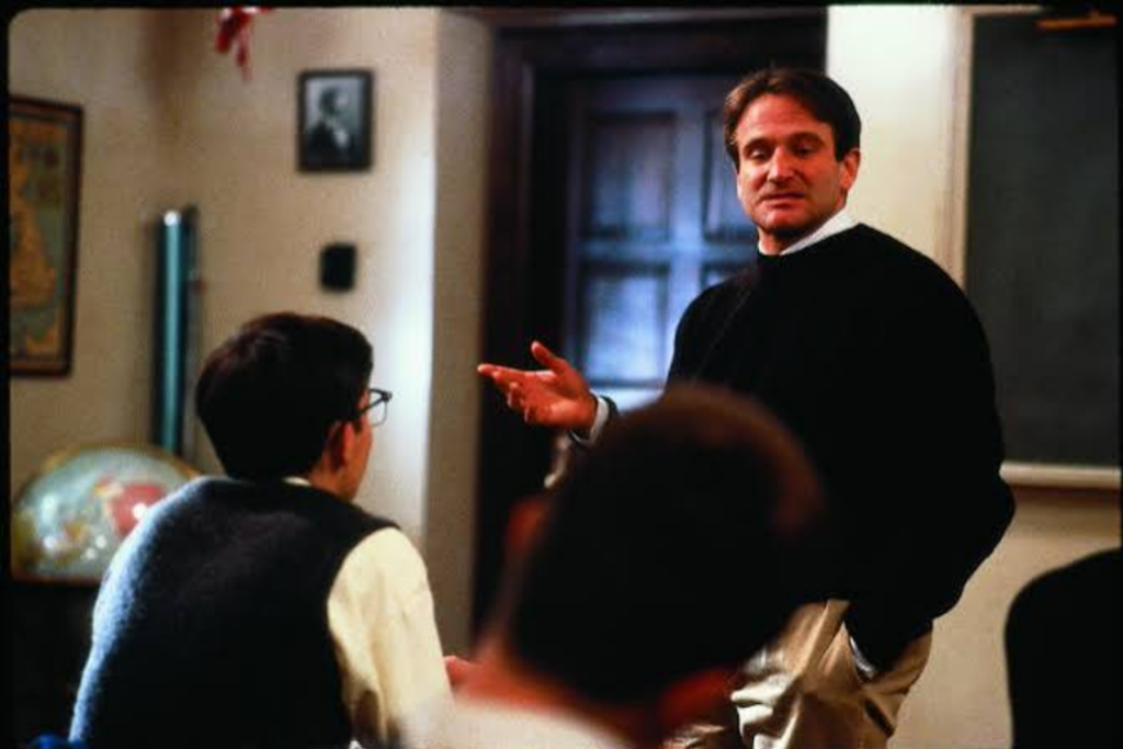 Robin Williams teaching students in a Dead Poets Society classroom scene
