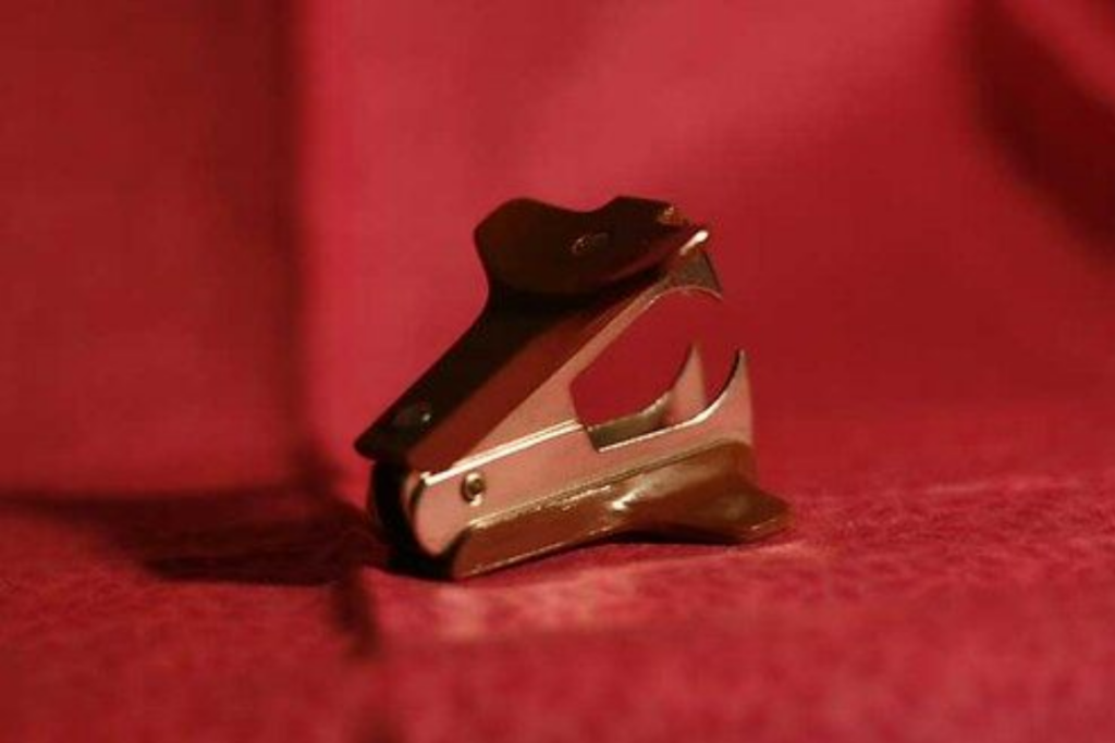 Staple remove with hook against a red background