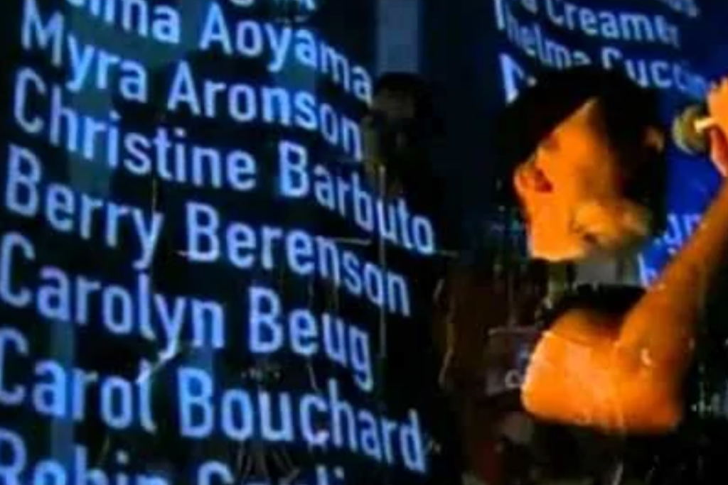 ono performing before the screen of victims’ names