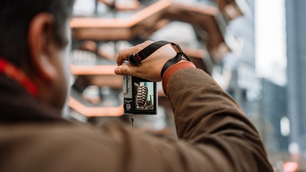 Man holding a camera, taking a picture.