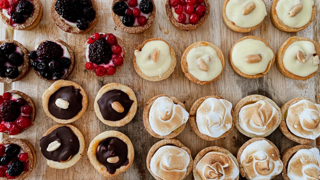 a wooden table topped with lots of pastries