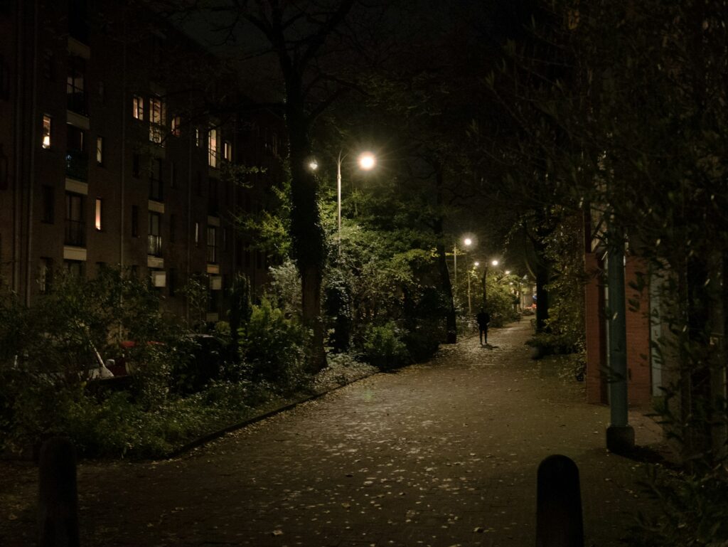 A dark street at night with street lights on