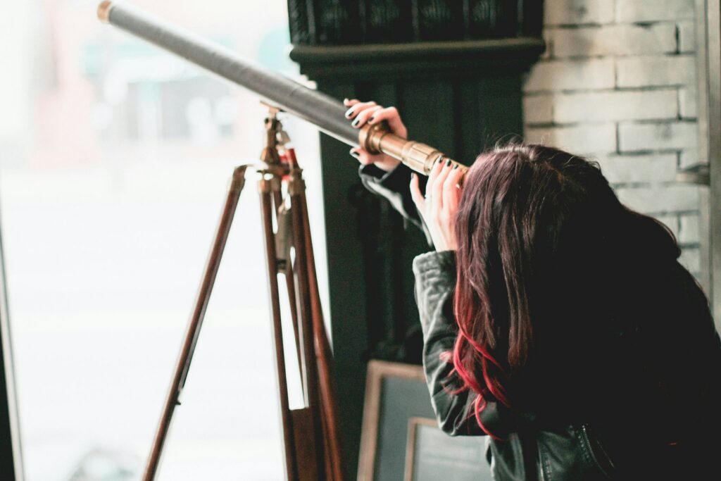 woman in gray jacket holding on brown metal bar