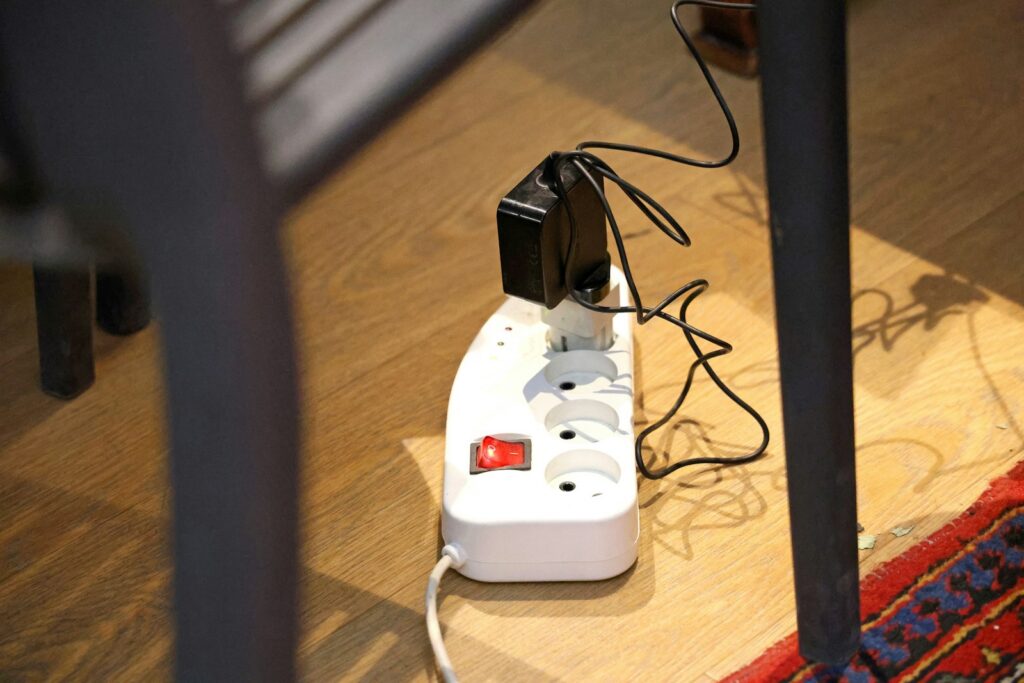 White power strip with plugs on a wooden floor.