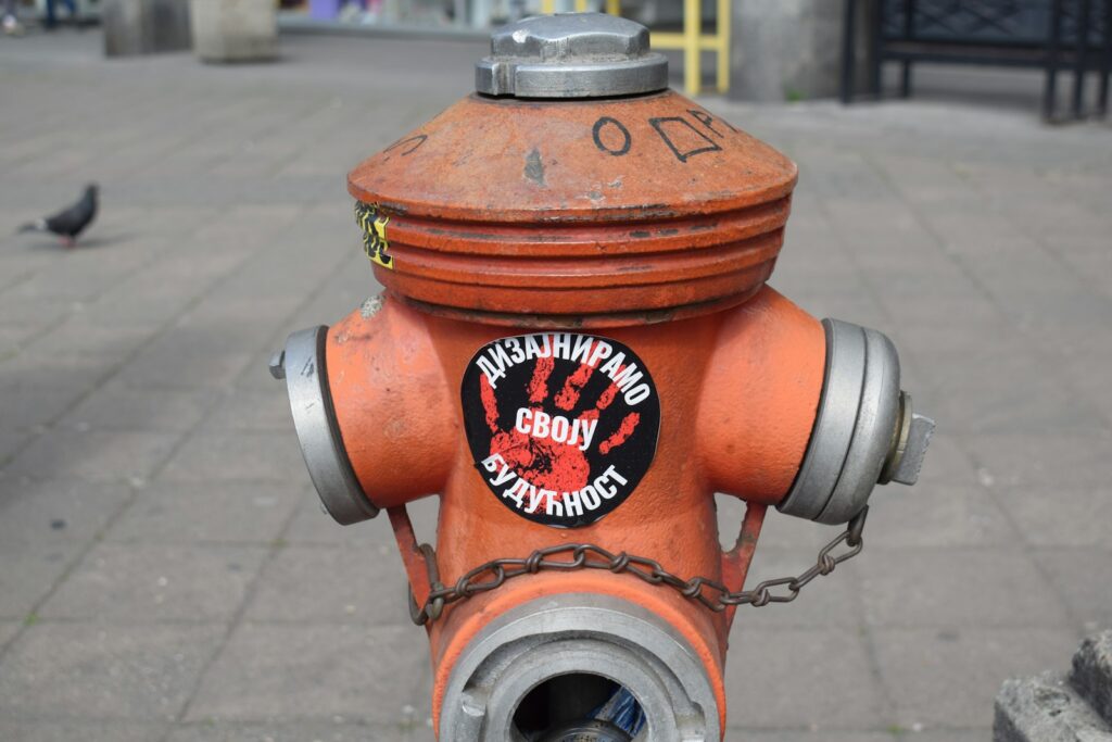 A detailed view of an old, orange fire hydrant.
