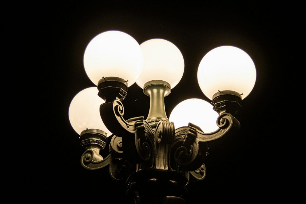 Street lamp with five glowing bulbs at night.