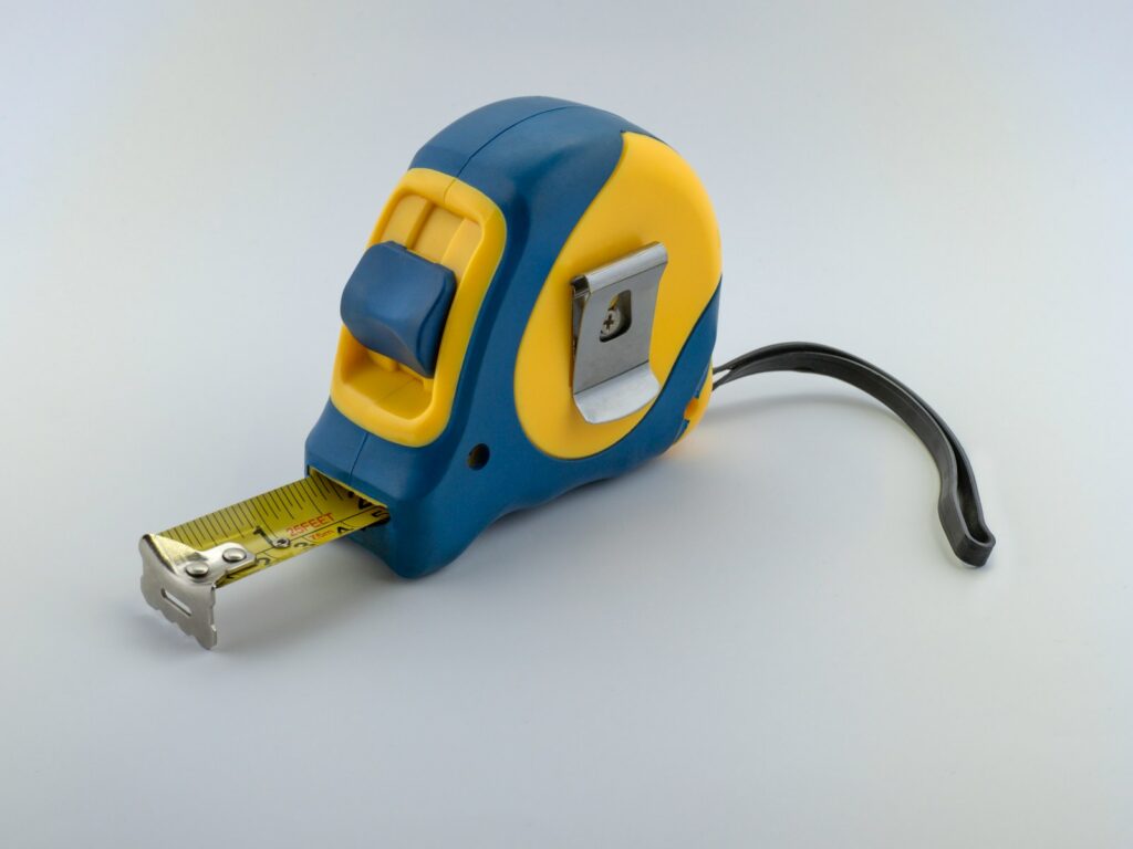 blue and yellow measuring tape with small hole near the end