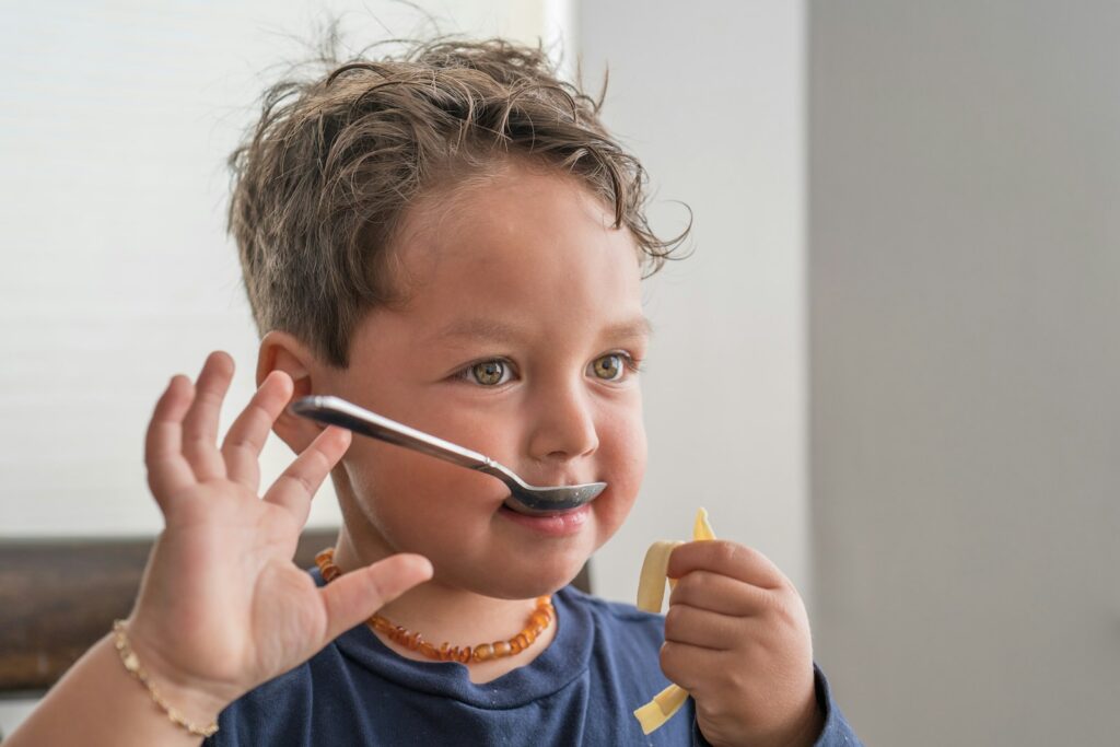 boy in blue crew neck shirt holding silver pen