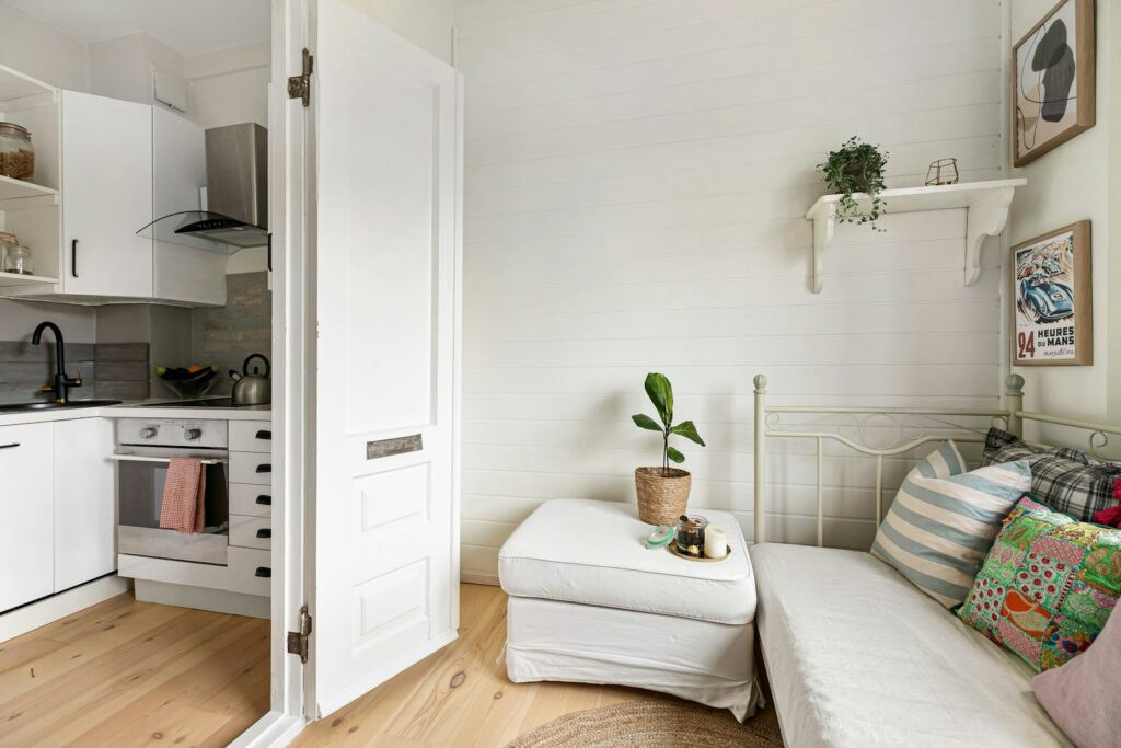 A kitchen with a white couch and a white refrigerator