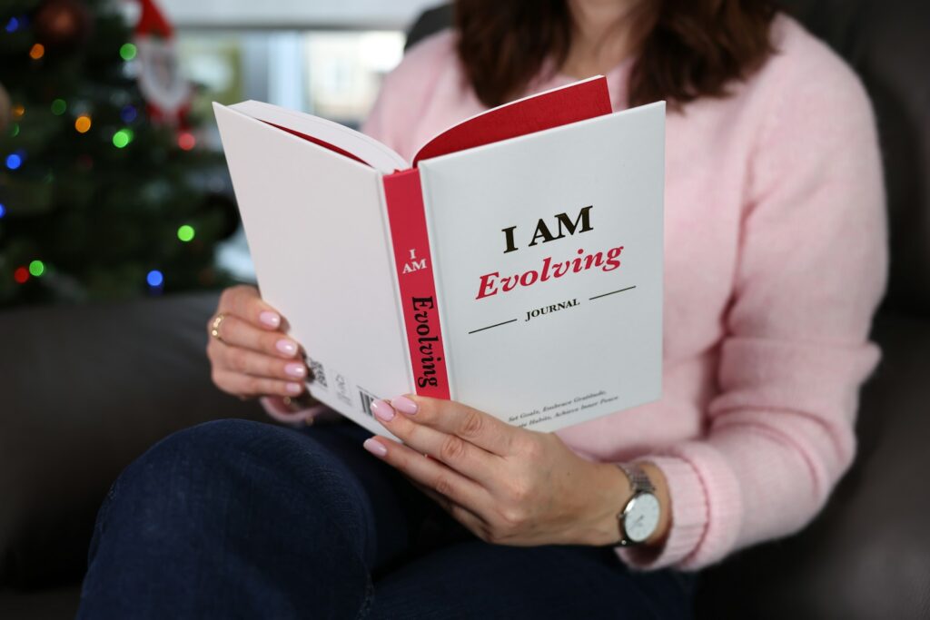 Woman reading a book titled "i am evolving"