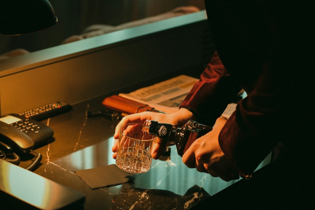 a person holding a glass of water near a phone