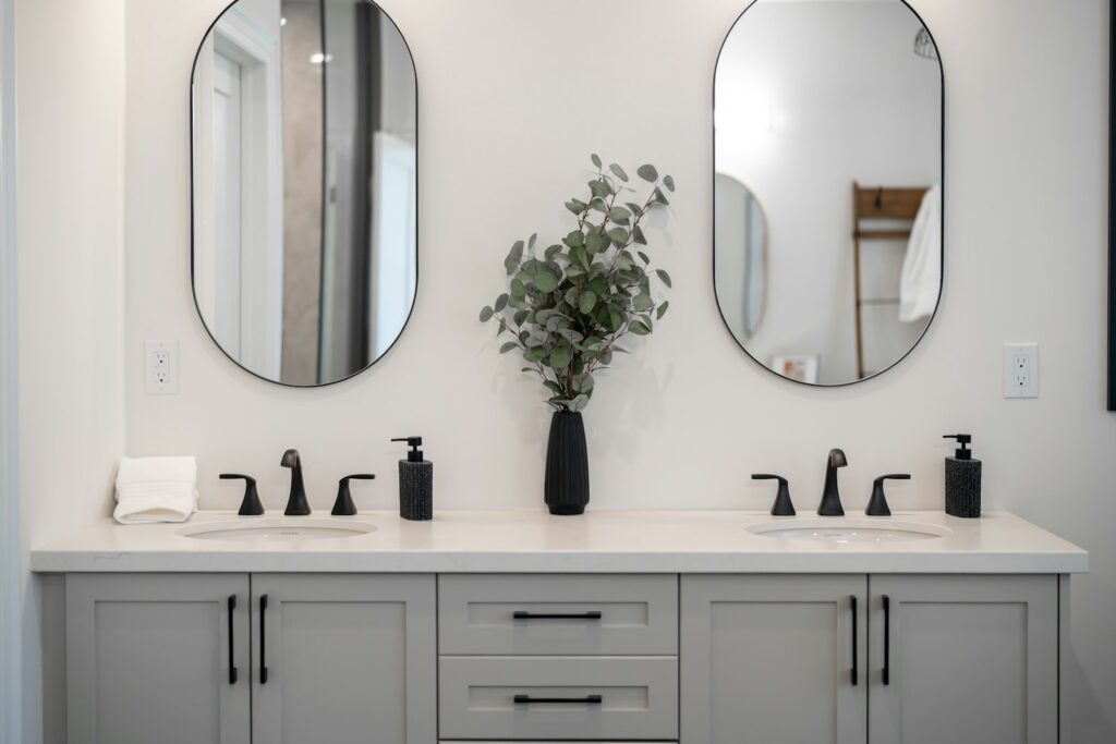 Modern bathroom vanity with double sinks and mirrors.