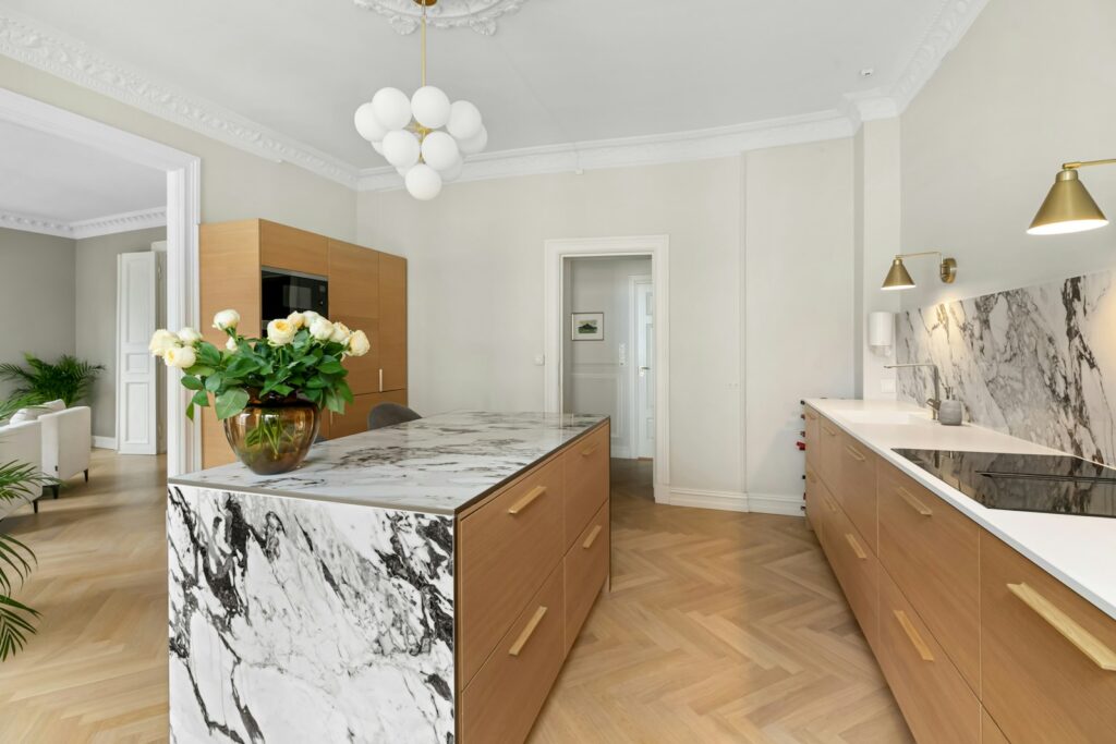A kitchen with marble counter tops and wooden cabinets