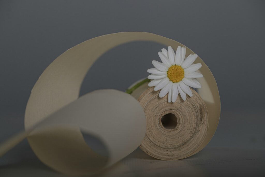 a white flower sitting on top of a roll of paper