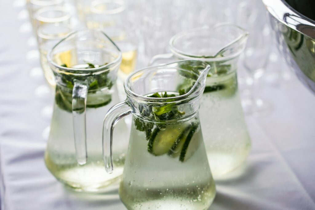 clear glass pitcher of infused water with cucumber