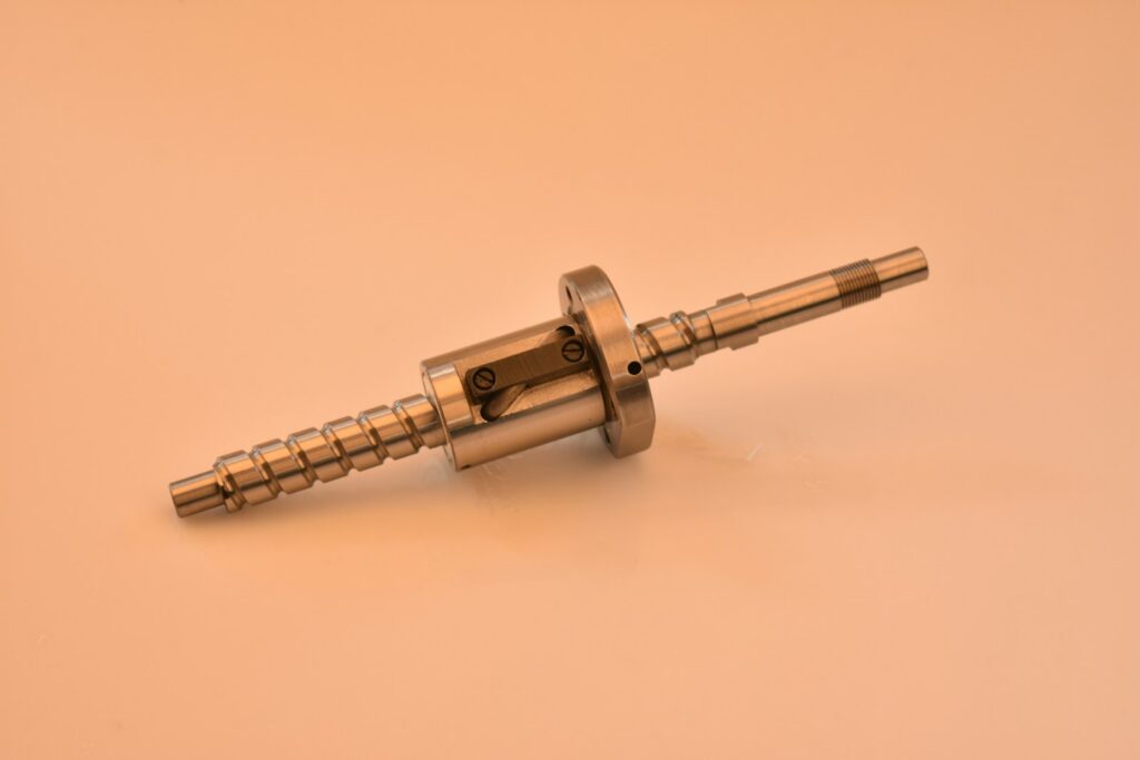 A metal screw and nut assembly on a light background.