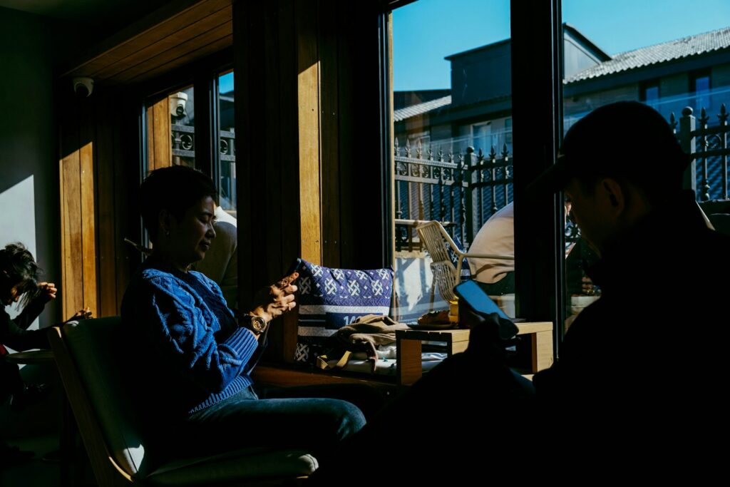a man sitting in a chair looking at his cell phone