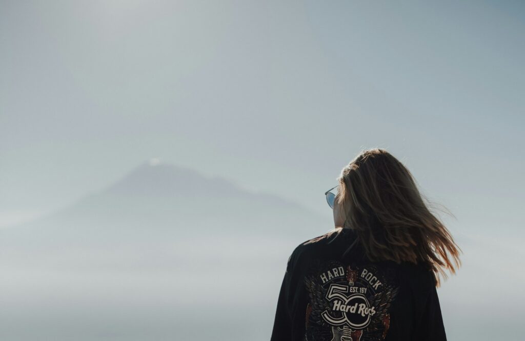 a woman looking at a mountain in the distance