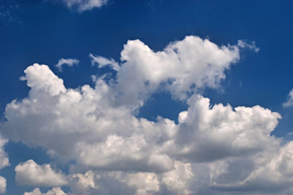Fluffy white clouds against a clear blue sky.