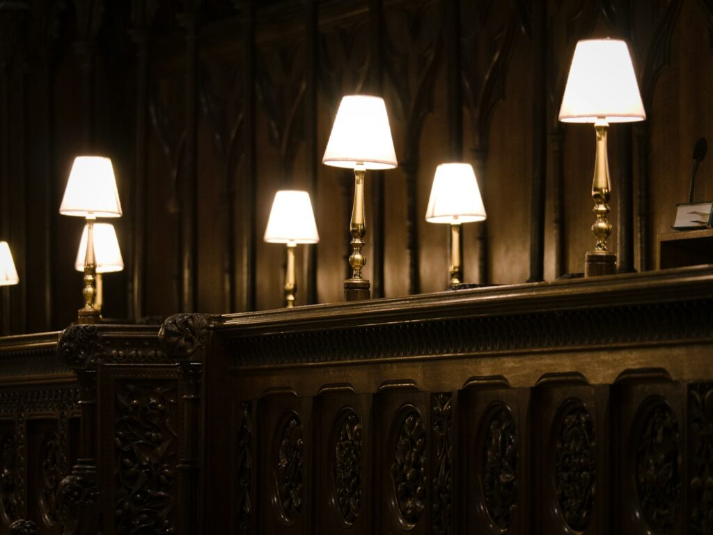 Several lamps on a wooden railing in a dark room.