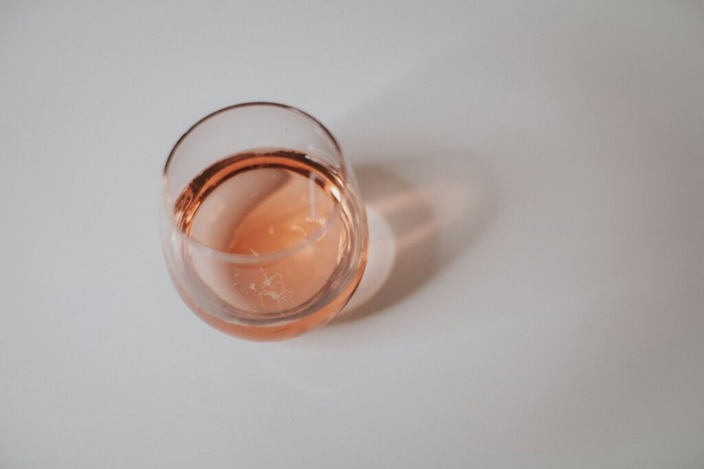 a glass of wine sitting on top of a white table