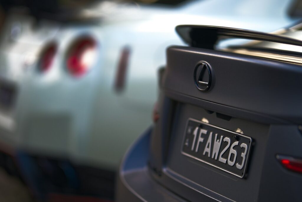 Rear view of a dark grey lexus and another car.