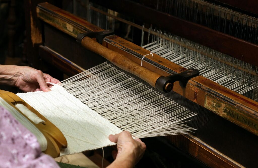person weaving in a loom