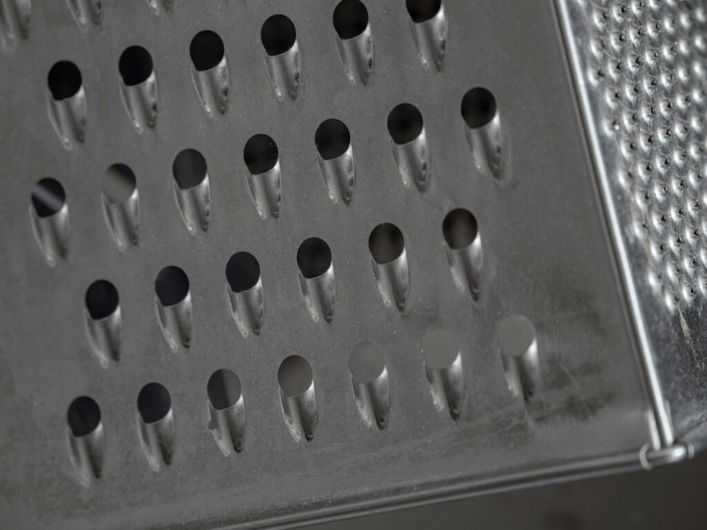 Close-up of a metal cheese grater surface.