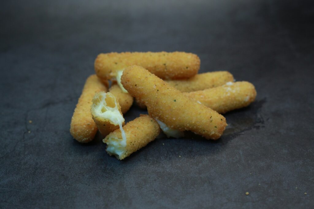 Several breaded mozzarella sticks with melted cheese.