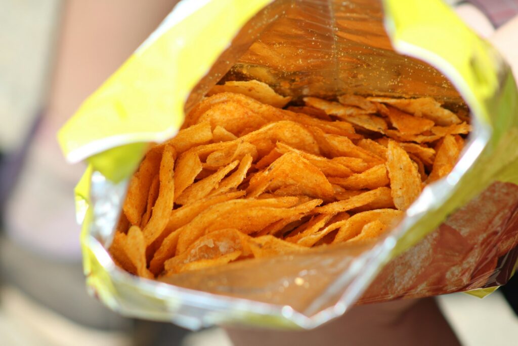 a close up of a person holding a bag of chips