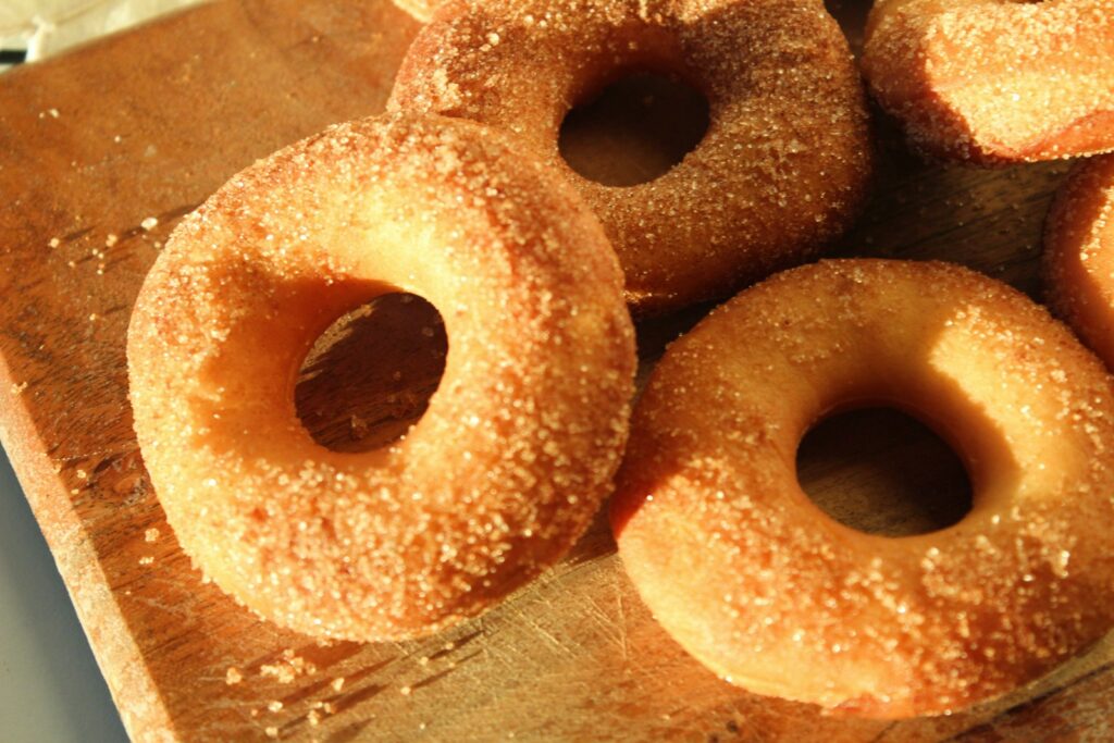 a pile of doughnuts sitting on top of a wooden cutting board