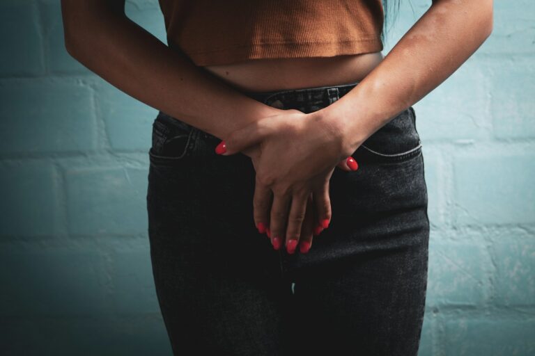 Woman in jeans and crop top covering herself