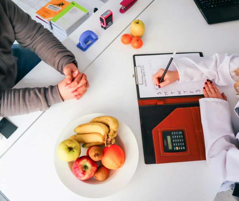 Doctor or dietitian consulting with a patient about nutrition with a plate of fruit
