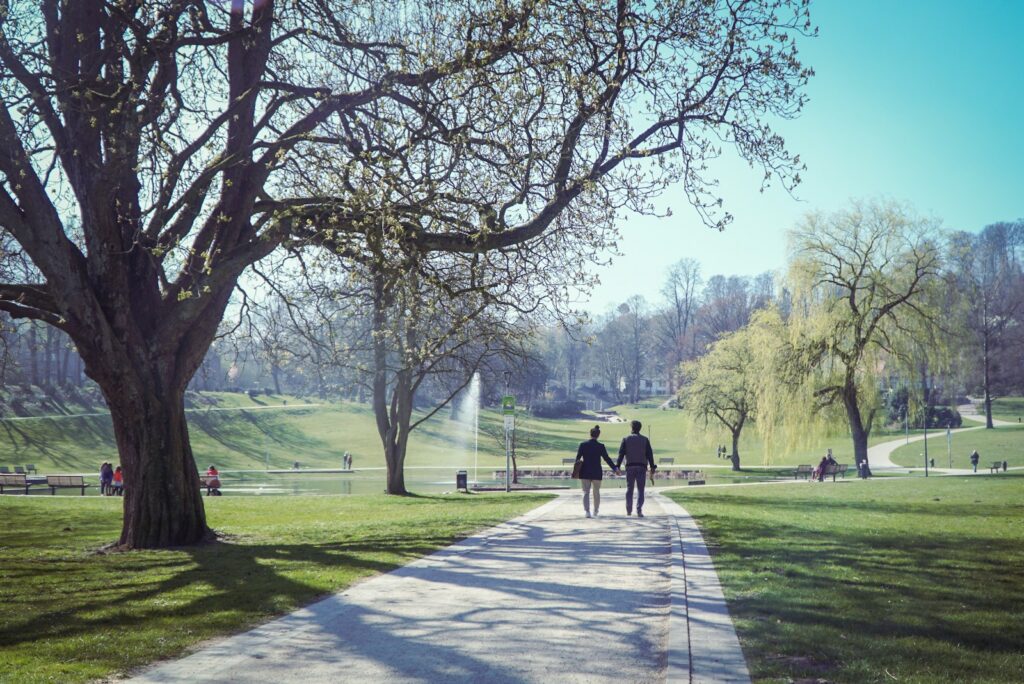 two people walking down a path in a park