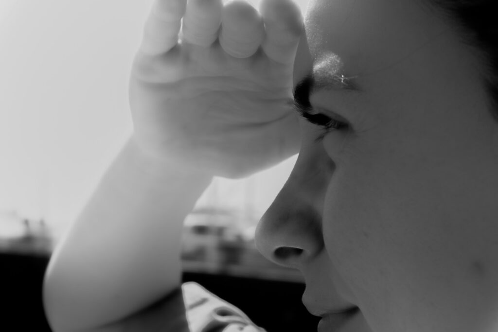 A person covers their eyes with a hand.