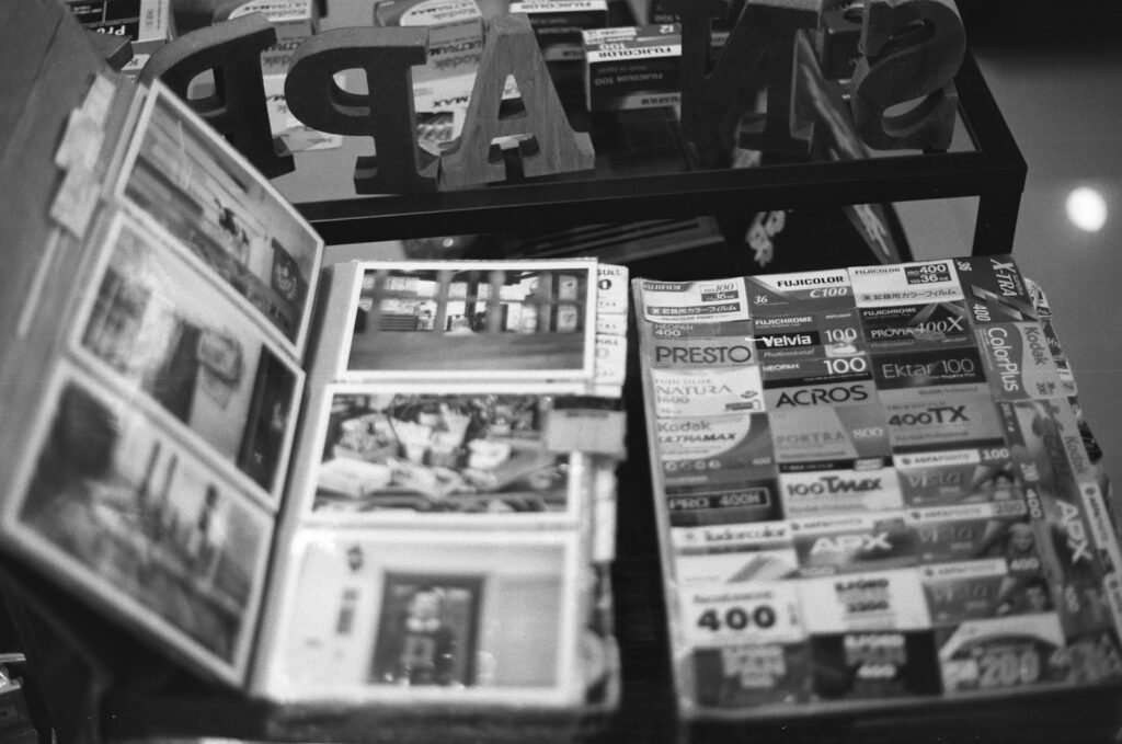 Open photo album displaying photographs beside stacked magazines.