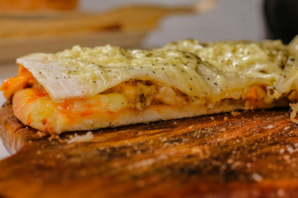 a piece of pizza sitting on top of a wooden cutting board