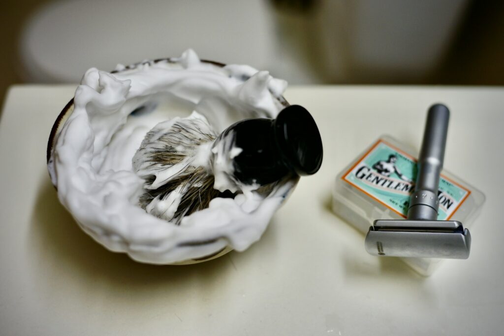 Fragrance-free shaving cream beside a razor on a bathroom counter