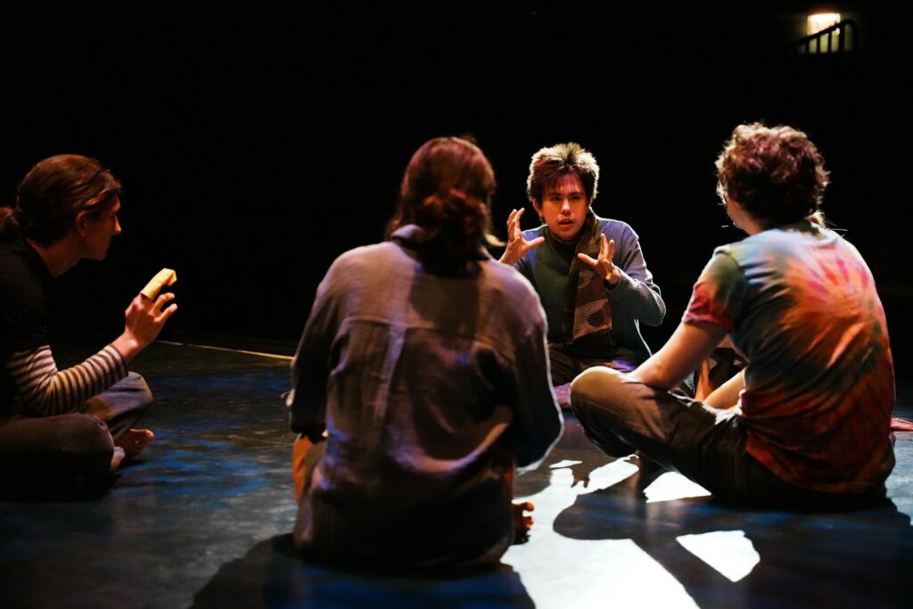 A group of people sitting on the floor talking