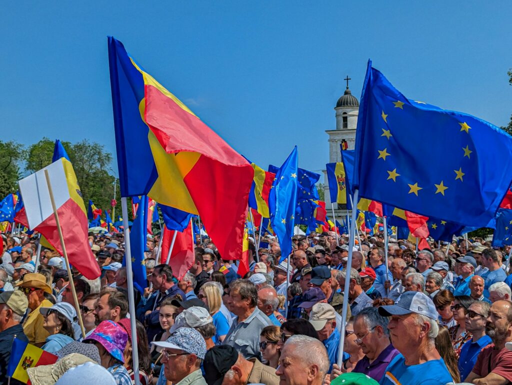 a large group of people holding different flags in front of a building