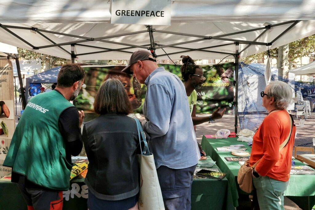 People at a greenpeace information booth