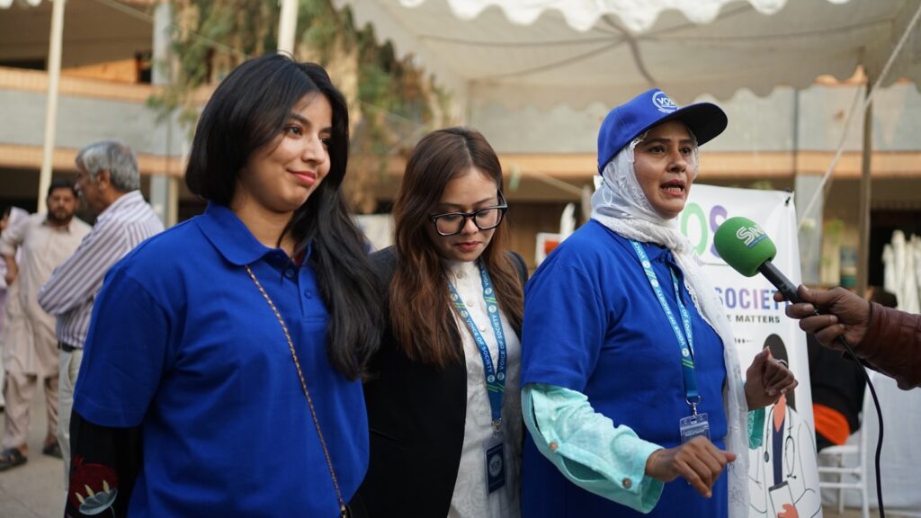 Three women in blue shirts being interviewed